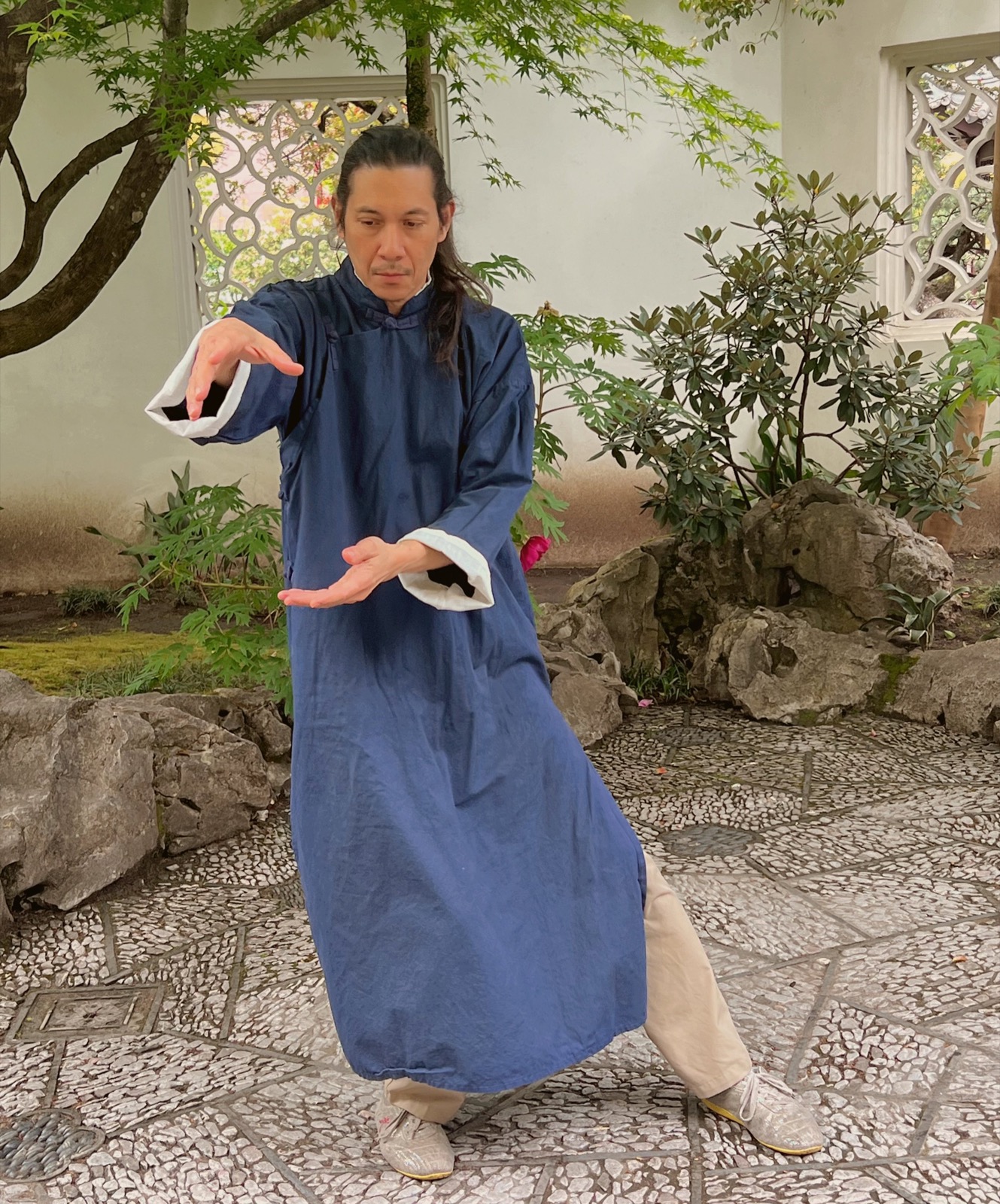 Eric Arthur in a tai chi posture in a garden