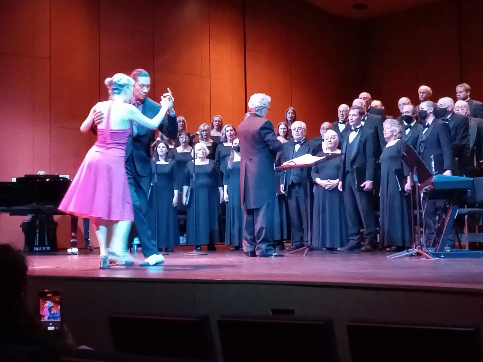 Eric dancing tango on stage in front of a choir